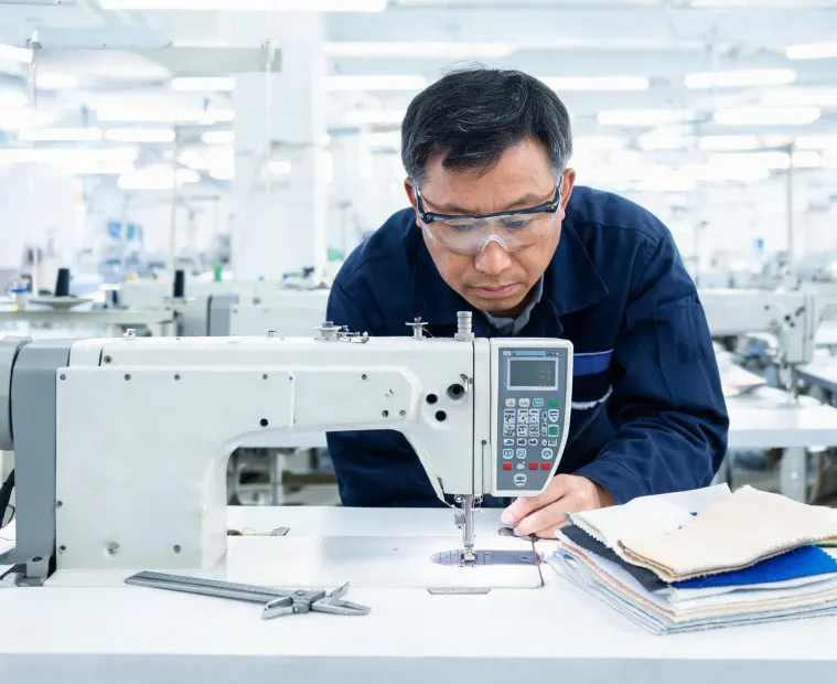 Technician inspecting JUKI sewing machine controls